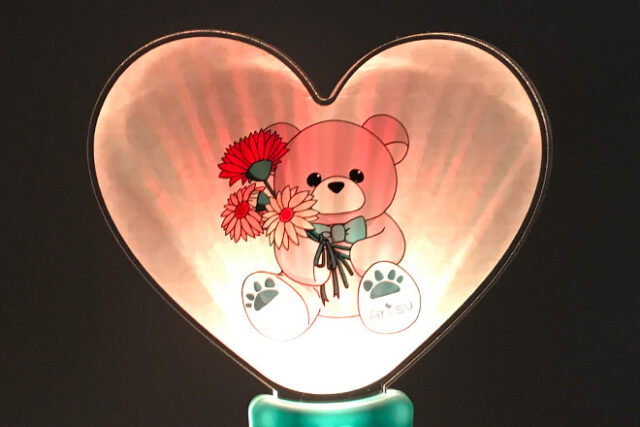 花を持つクマのぬいぐるみが描かれたハート型ペンライト